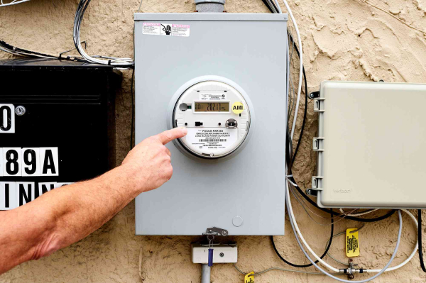Elektrische meter buitenshuis wordt geïnspecteerd