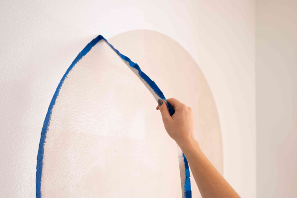 Schildertape van de muur verwijderd om de zelfgemaakte geschilderde boog bloot te leggen