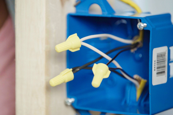 Draden bedekt met gele deksels voordat ze in de elektrische aansluitdoos worden gevouwen
